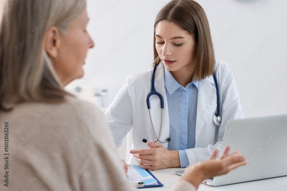 Young healthcare worker consulting senior patient in hospital Young healthcare worker consulting senior patient in hospital