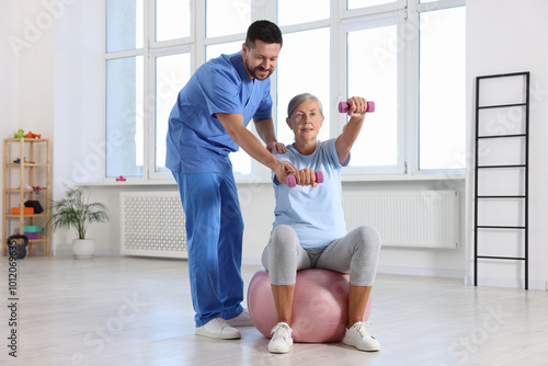 Senior patient exercising under physiotherapist supervision in rehabilitation center