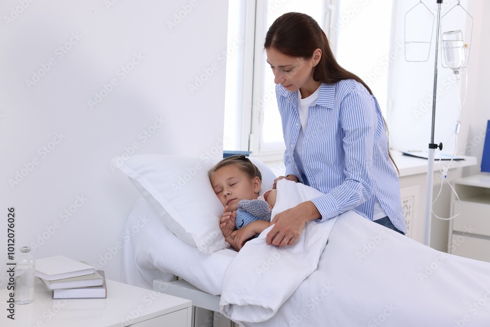 Obraz premium Mother and her little daughter on bed in hospital