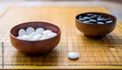 Two bowls with white and black round stones for Korean board game Go. Wei-chi, Chinese game. photo