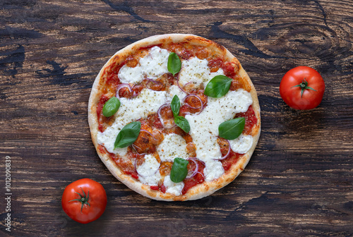 Pizza with tomato sauce, mozzarella cheese, red onion and fresh basil on wooden background. Top view