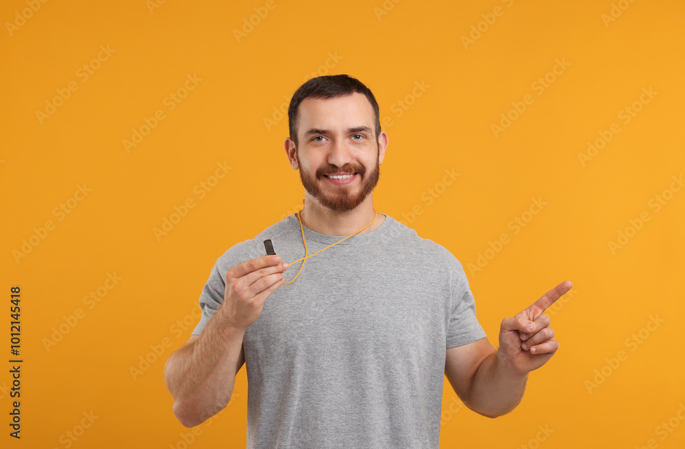 Happy young man with whistle on orange background Happy young man with whistle on orange background