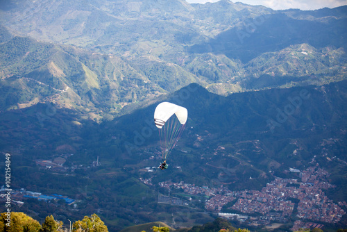 People paragliding over the beautiful mountains of the Antioquia department in Colombia. Tandem Paragliding. Extreme sport concept.