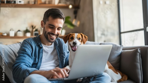 A man with his dog working at laptop computer at home