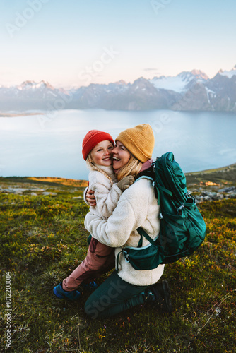 Family time - mother hugging child hiking together, travel lifestyle outdoor active vacations in mountains of Norway parent and kid daughter happy candid emotions