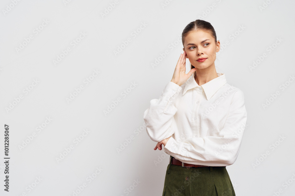 Attractive woman with thoughtful expression in a white shirt against a light background, showcasing a confident yet contemplative pose Stylish outfit highlights modern fashion Attractive woman with thoughtful expression in a white shirt against a light background, showcasing a confident yet contemplative pose Stylish outfit highlights modern fashion