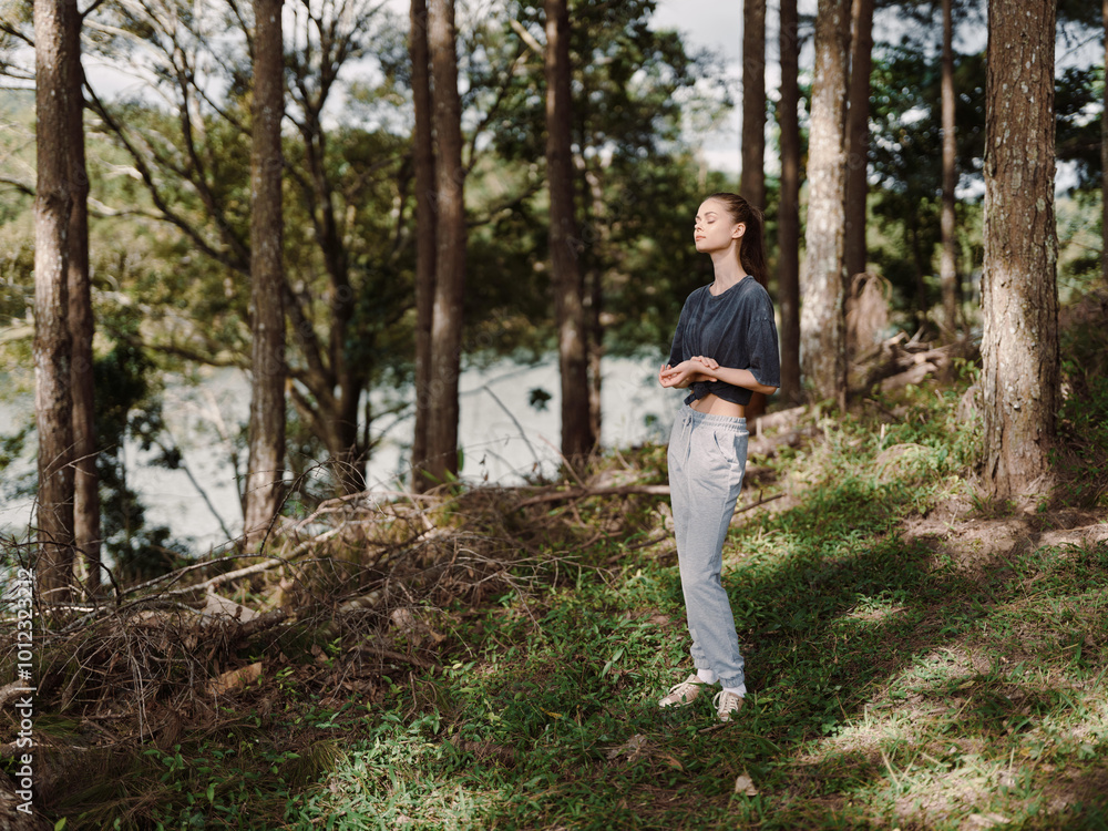 Calm young woman enjoying nature, standing peacefully among trees, feeling the fresh air in a serene outdoor environment Connection to nature and mindfulness concept Calm young woman enjoying nature, standing peacefully among trees, feeling the fresh air in a serene outdoor environment Connection to nature and mindfulness concept