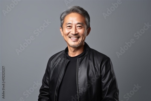 Portrait of a happy mature asian man in black leather jacket