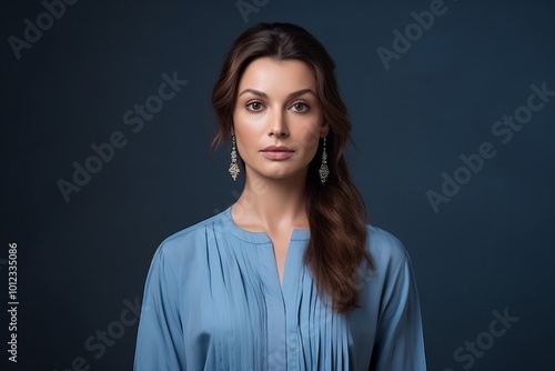 Portrait of a beautiful brunette woman in a blue dress.