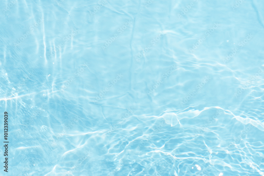 Obraz premium Blue water with ripples on the surface. Defocus blurred transparent blue colored clear calm water surface texture with splashes and bubbles. Water waves with shining pattern texture background.