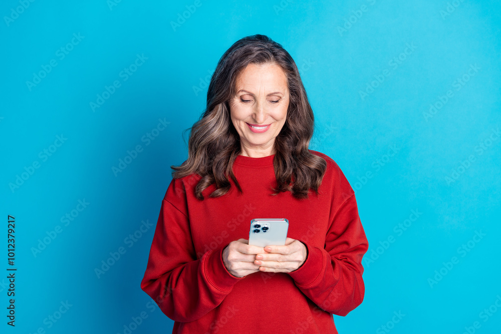 Portrait of nice aged woman use phone wear red sweater isolated on blue color background Portrait of nice aged woman use phone wear red sweater isolated on blue color background