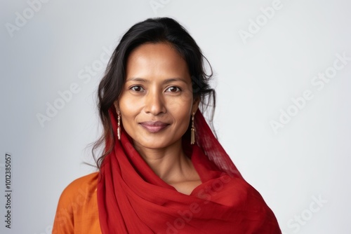 Portrait of a beautiful Indian woman wearing a red scarf smiling at the camera