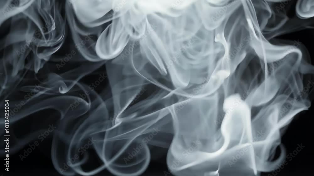 Thick clouds of white smoke swirling in the air, creating abstract shapes against a dark backdrop. The contrast between light and dark emphasizes the smoky texture. Thick clouds of white smoke swirling in the air, creating abstract shapes against a dark backdrop. The contrast between light and dark emphasizes the smoky texture.