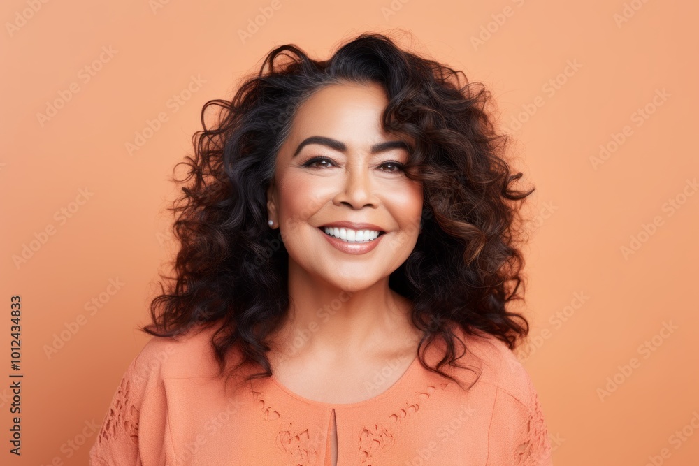 Portrait of a beautiful smiling young woman with curly hair, over orange background Portrait of a beautiful smiling young woman with curly hair, over orange background