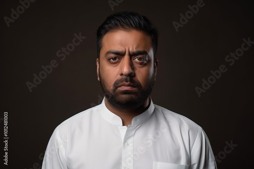 Portrait of a pensive man in a white shirt on a dark background