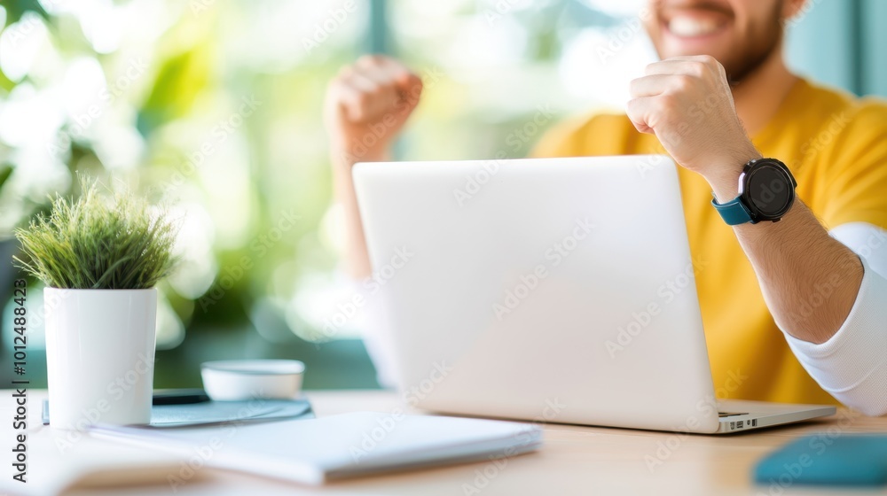 A joyful man with raised fists celebrates success at his desk in a bright, modern office setting, conveying a sense of achievement and motivation. A joyful man with raised fists celebrates success at his desk in a bright, modern office setting, conveying a sense of achievement and motivation.