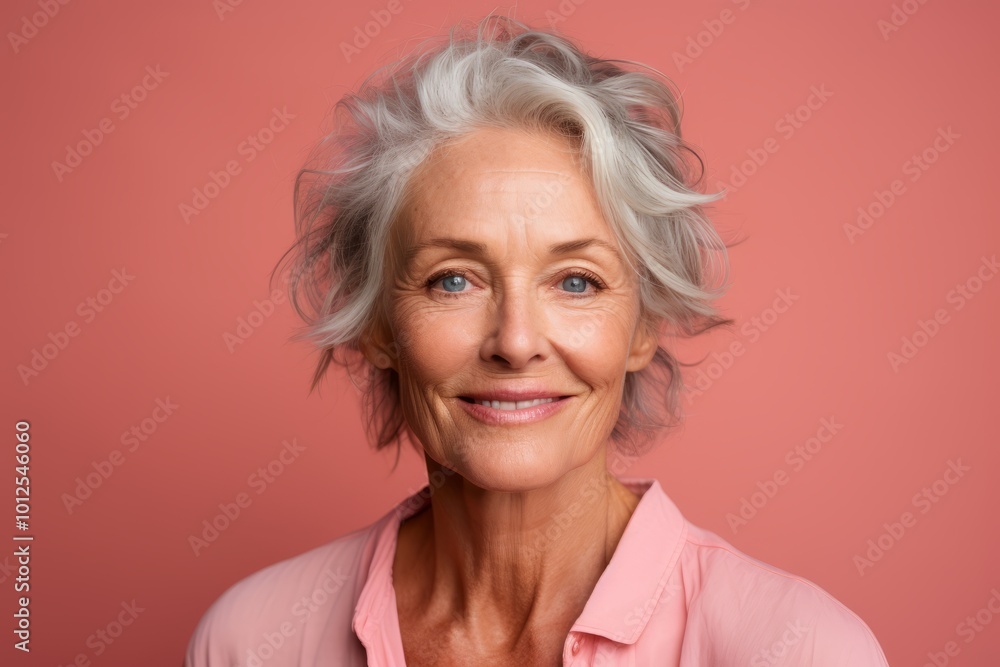 Portrait of smiling senior woman with grey hair on pink background. Portrait of smiling senior woman with grey hair on pink background.