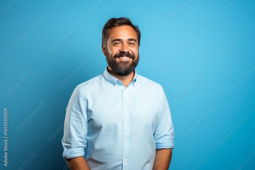 Handsome young man with beard and mustache smiling on blue background Handsome young man with beard and mustache smiling on blue background
