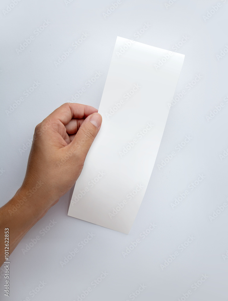Hand hold white empty shopping receipt mockup on gray background. Template for design. Places for text Hand hold white empty shopping receipt mockup on gray background. Template for design. Places for text