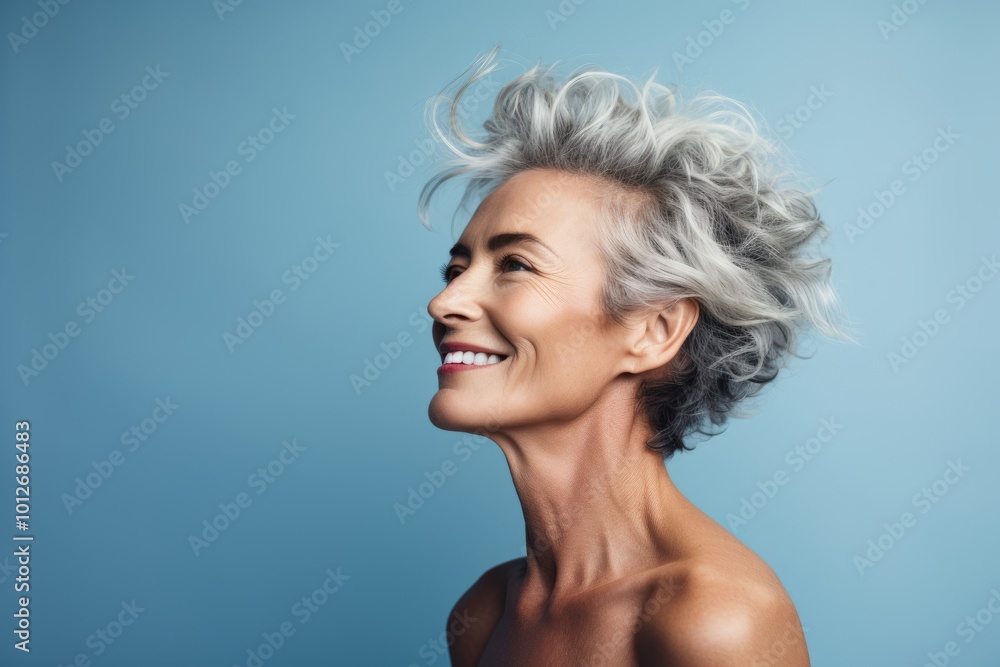 Portrait of beautiful mature woman with short grey hair on blue background Portrait of beautiful mature woman with short grey hair on blue background