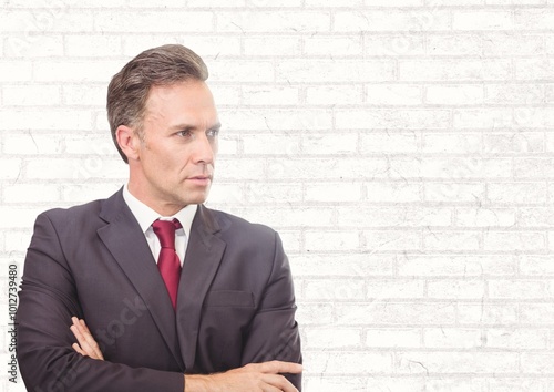 Caucasian businessman with arms crossed against copy space on brick wall background