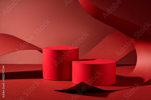 The image is ideal for presenting products, featuring two red cylindrical podiums on a red background, curled and arched over by a large piece of red paper curled and arched over them. photo