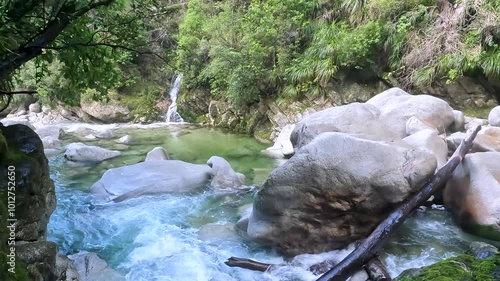 Wainui Falls: A Stunning Waterfall Cascading Through Rocks and Lush Native Forest in New Zealand's Tasman Region photo