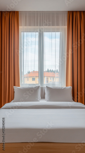 A cozy bedroom with large windows showcasing outdoor scenery and soft curtains