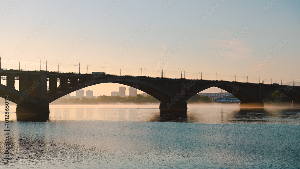 Fototapeta premium the bus goes over the bridge in Krasnoyarsk at dawn