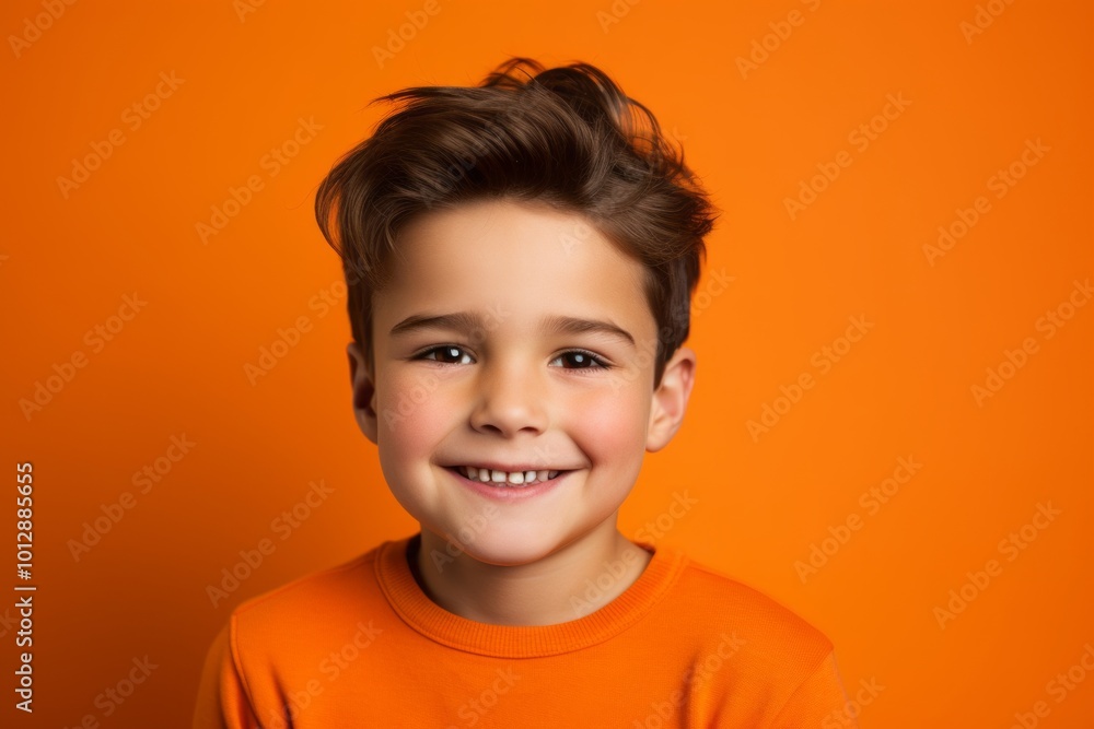 Portrait of a smiling little boy on a bright orange background. Portrait of a smiling little boy on a bright orange background.