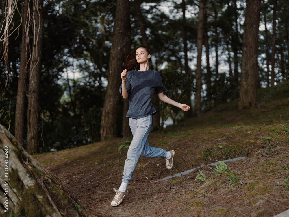 Energetic young woman jogging in a serene forest, enjoying outdoor fitness and healthy lifestyle, wearing casual athletic clothing and a determined expression Energetic young woman jogging in a serene forest, enjoying outdoor fitness and healthy lifestyle, wearing casual athletic clothing and a determined expression