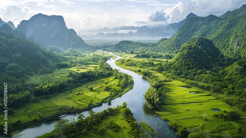 A quiet river meanders through a green valley, with lush vegetation and distant mountains