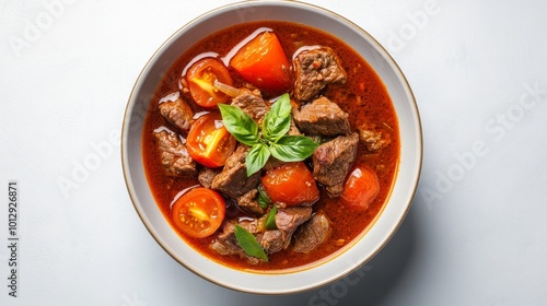 A close-up of a savory beef stew, featuring tender chunks of beef, fresh tomatoes, and fragrant basil. The vibrant colors and rich broth make this a hearty and comforting dish perfect for any meal