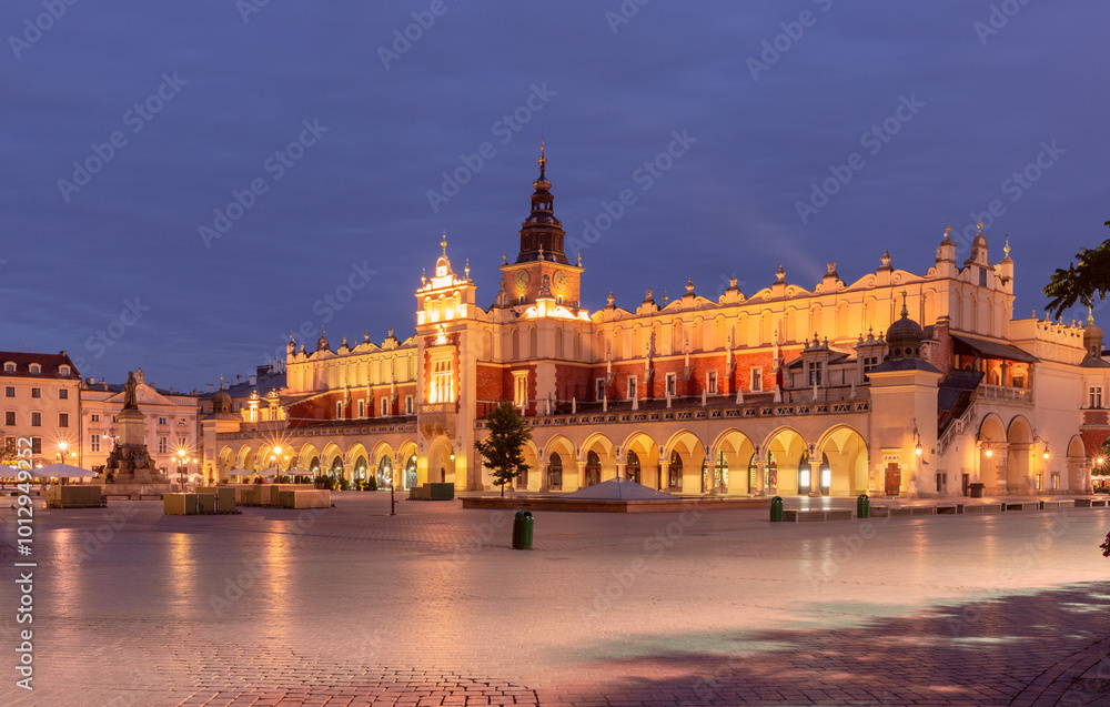 The Cloth Hall in Krakow, Poland, photographed at dawn in the Main Market Square. The illuminated Renaissance-style building stands prominently with its arches and tower visible The Cloth Hall in Krakow, Poland, photographed at dawn in the Main Market Square. The illuminated Renaissance-style building stands prominently with its arches and tower visible