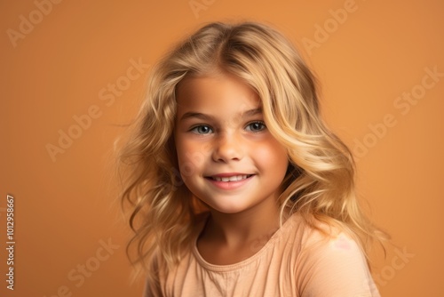 Portrait of a cute little girl with long blond hair. Studio shot.