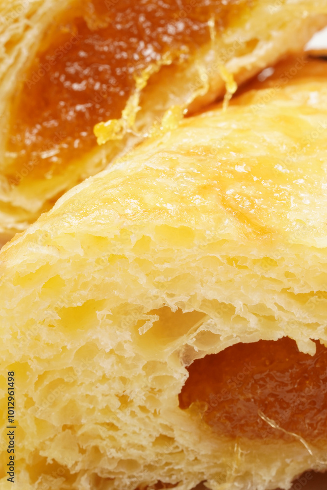 A golden-yellow pastry filled with sweet yellow pineapple jam, offering a deliciously sweet taste. Photographed on a white background. A golden-yellow pastry filled with sweet yellow pineapple jam, offering a deliciously sweet taste. Photographed on a white background.