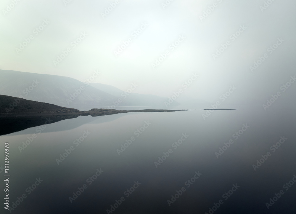 Lake with rippling water reflecting shadow of surrounding hills Lake with rippling water reflecting shadow of surrounding hills
