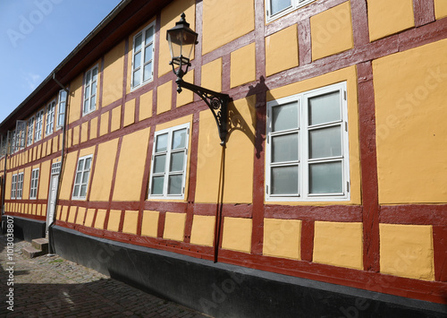 traditional danish house with small square paned windows and a scraped stucco facade on a narrow cobblestone street photo