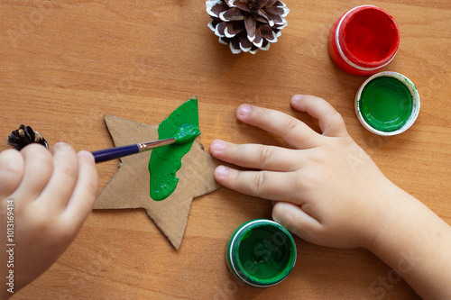 child draws with paints, hands close-up