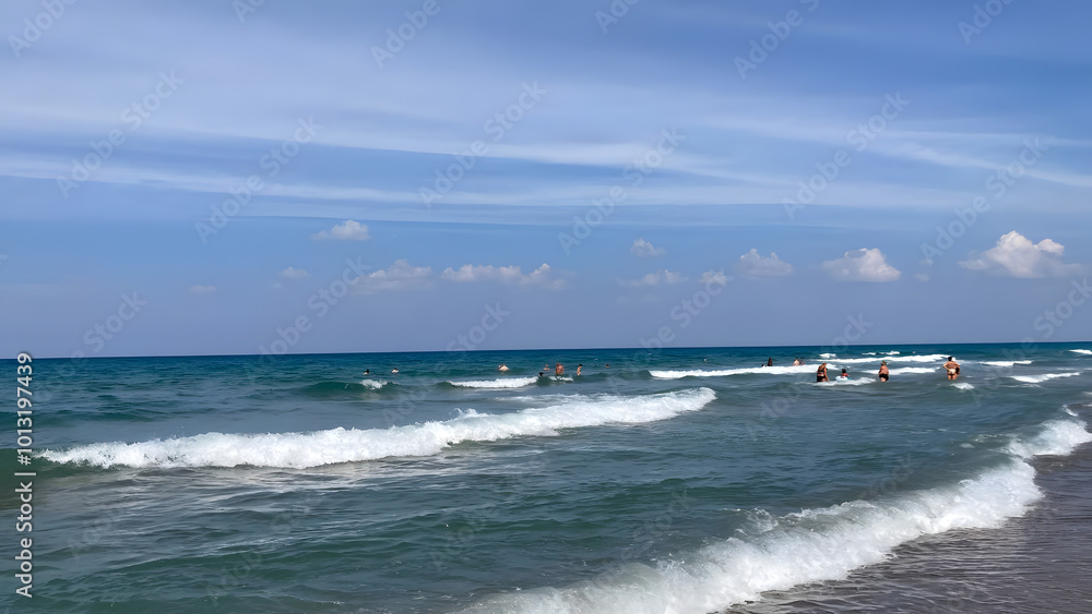 Greek sea waves sky without clouds in the distance people are swimming Greek sea waves sky without clouds in the distance people are swimming