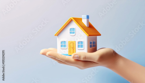 Hand holding a miniature house isolated against a soft background.