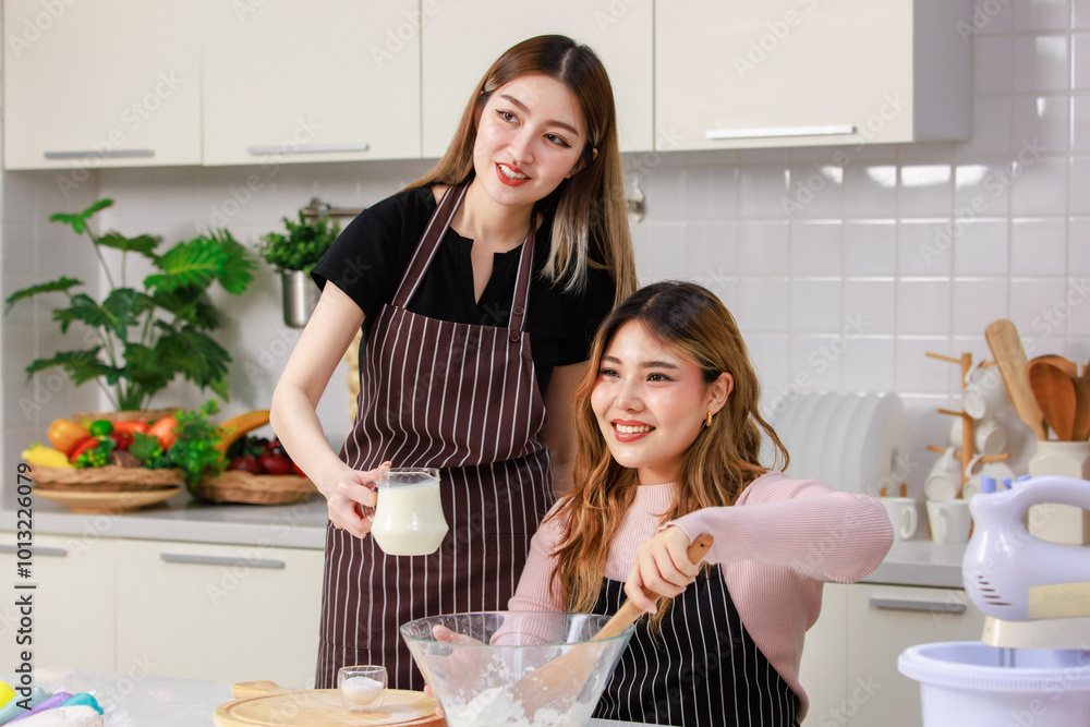 Cute happy two young Asian female friends, woman wearing aprons, preparing dessert tasty sweet for party cooking dough baking cakes. Concept hobby enjoy weekends in kitchen teenage lifestyle at home. Cute happy two young Asian female friends, woman wearing aprons, preparing dessert tasty sweet for party cooking dough baking cakes. Concept hobby enjoy weekends in kitchen teenage lifestyle at home.