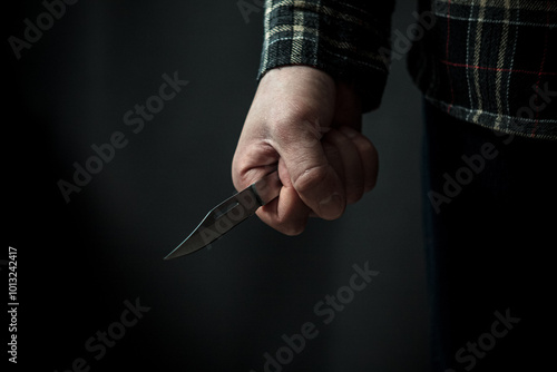 A man with a knife in his hand is the embodiment of a tense moment where crime photo