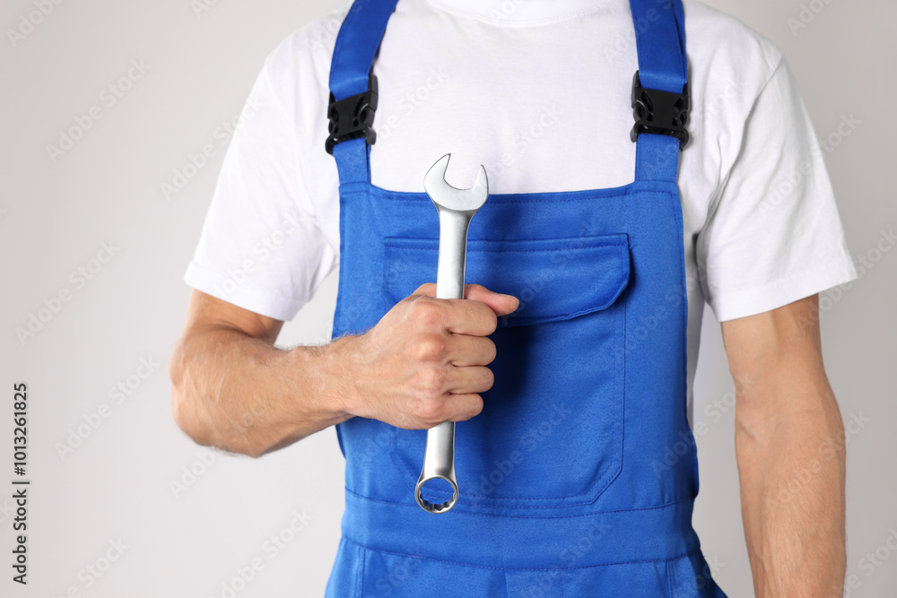 Auto mechanic with wrench on light grey background, closeup Auto mechanic with wrench on light grey background, closeup