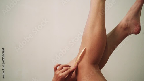 Beautiful well-groomed female legs close-up on gray isolated background, epilation concept of leg skin care or getting rid of cellulite.