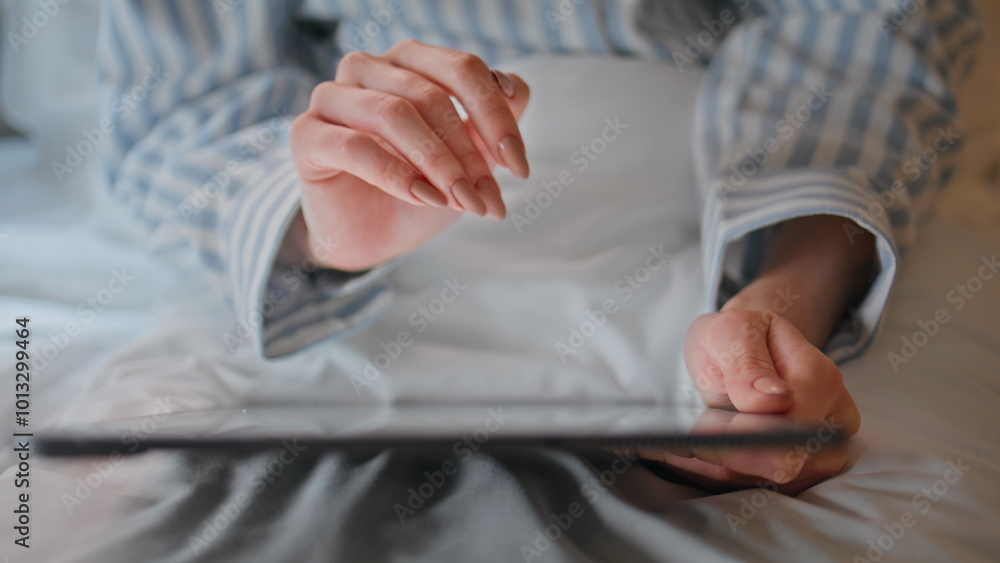 Woman hands swiping tablet on cozy white bed closeup. Woman planning work on pad Woman hands swiping tablet on cozy white bed closeup. Woman planning work on pad