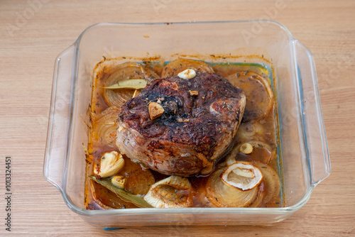 Foto Delicious roasted lamb shank in a glass baking dish, beautifully browned and garnished with herbs, capturing the essence of home-cooked comfort food
