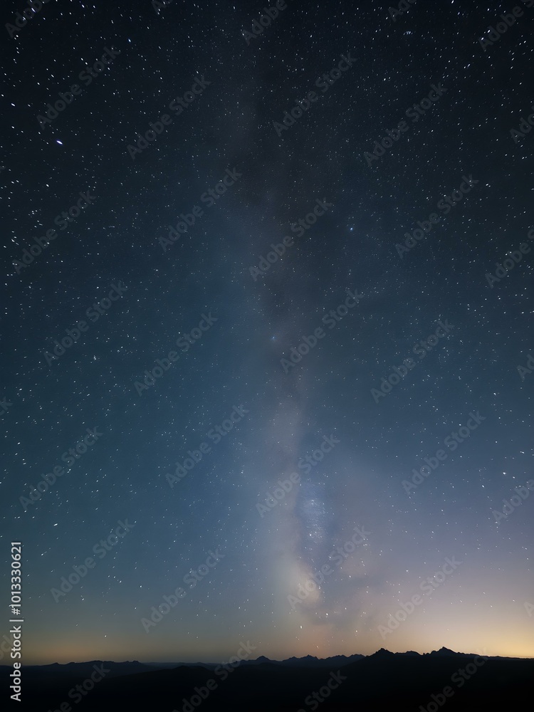 Obraz premium A stunning night sky filled with countless stars, the Milky Way glowing brightly across the horizon, and soft silhouettes of mountains in the distance 
