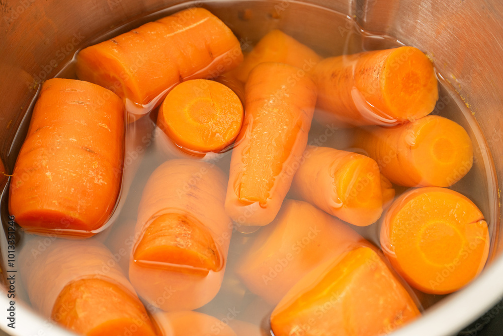 Close-up of vibrant orange carrots being cooked in a kitchen robot, showcasing their natural color and texture, perfect for healthy cooking imagery. Close-up of vibrant orange carrots being cooked in a kitchen robot, showcasing their natural color and texture, perfect for healthy cooking imagery.