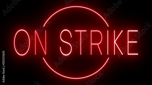 Flickering red retro style neon sign glowing against a black background for ON STRIKE photo